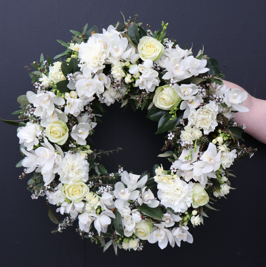 hand holding beautiful white and green wreath